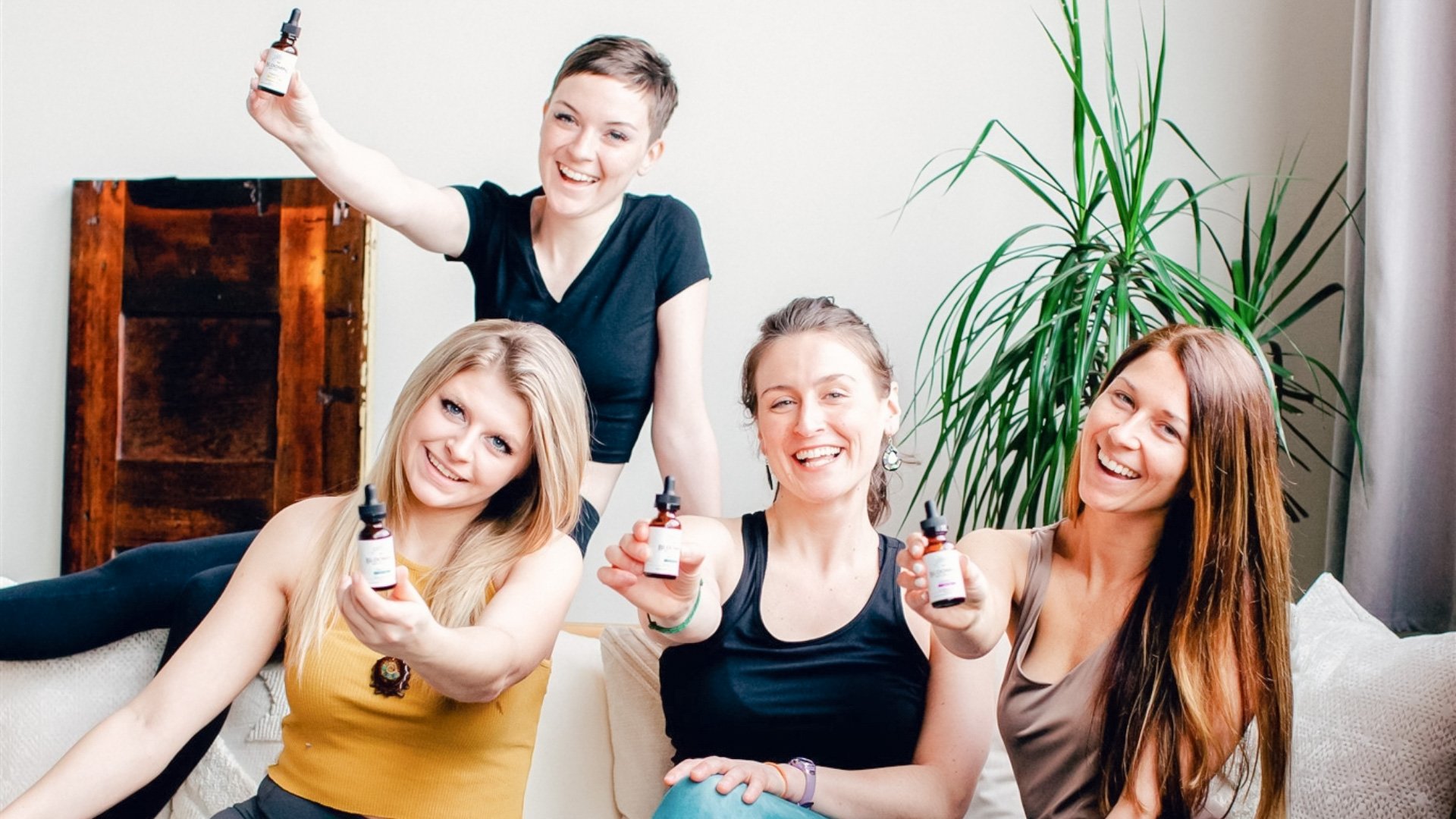 4 women holding CBD tinctures and smiling